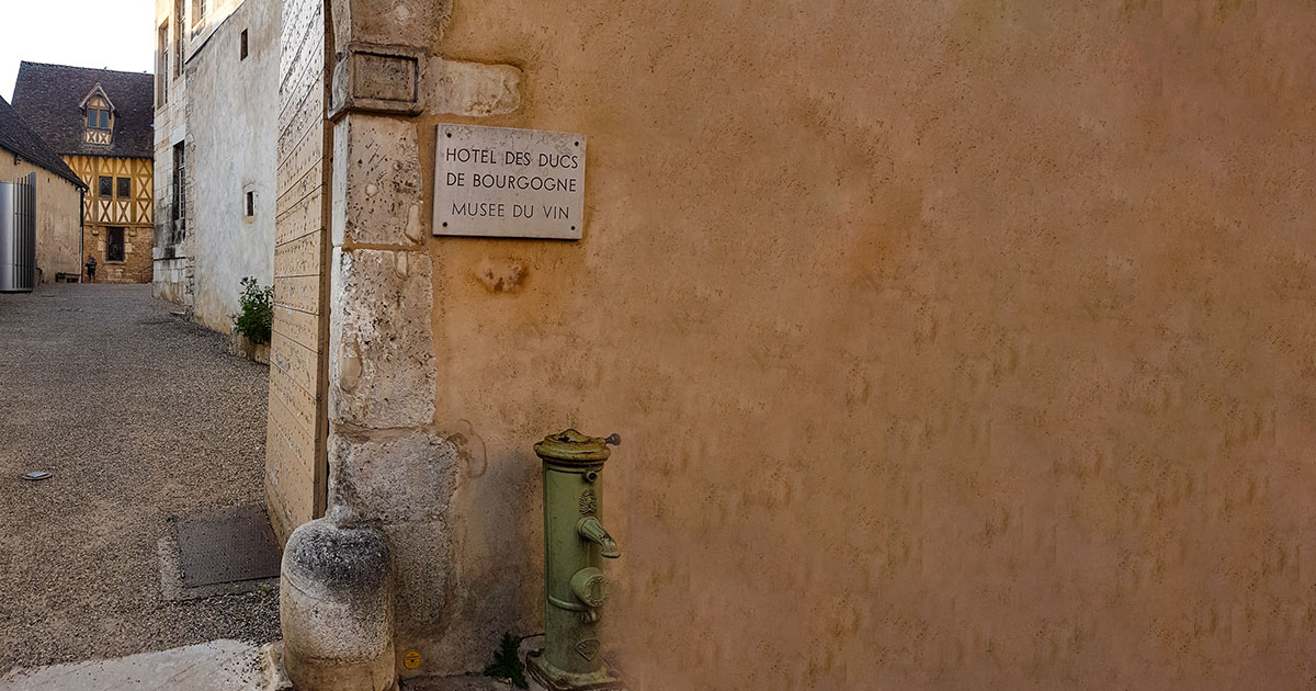 Eingangsbereich am Tor von dem Weinmuseum in Burgund. Es ist ein Schild mit "Musée du Vin" zu sehen.